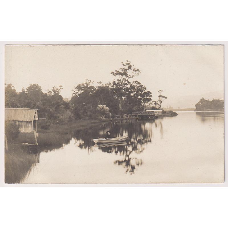 (BB1898) TASMANIA · c.1910: real photo card with a view of a young woman in a dinghy on a serene Huon River in the WOODSTOCK area · message on verso but not postally used · VF condition