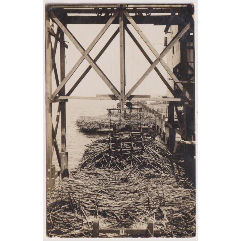 (PT1005)  NEW SOUTH WALES · 1909: real photo card w/view of a crane loading sugar card on to a barge on HARWOOD ISLAND · mailed from there with clear "rays" numeral cancel '754' which is rated S · fine condition