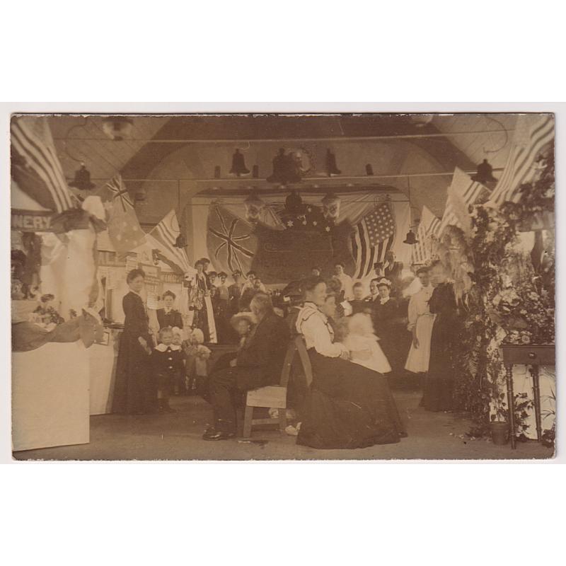 (WW1586) TASMANIA · c.1910: T.R.G. Williams, Scottsdale  (stamp on verso) real photo card w/portrait of attendees at a event at the Methodist Sunday School Hall · too early for a WWI fundraiser (note home-made USA flags)  further research required!