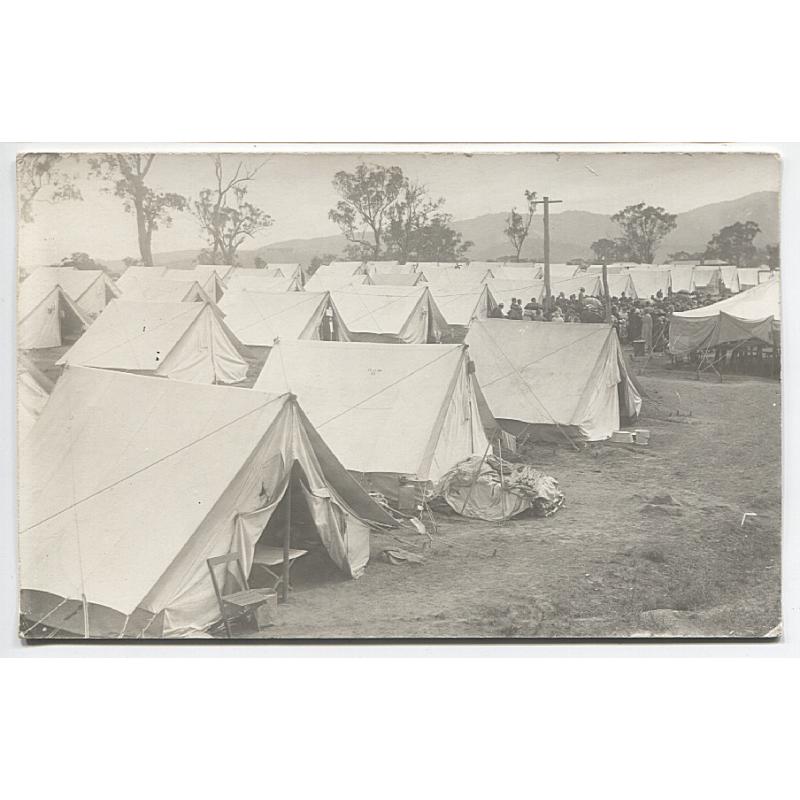 (YY1065) TASMANIA · 1920s: unused real photo card with a view of an encampment  ..... the untidy site and many women in a distant crown indicates that is unlikely to be a military camp · see description